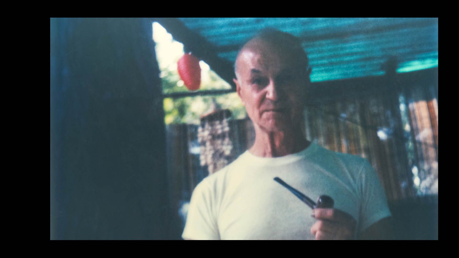 Grainy, retro-style amateur photo showing a middle-aged man looking to camera.