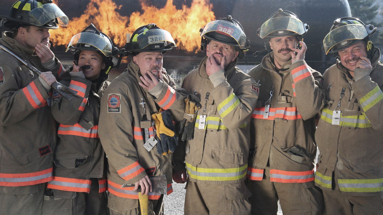 Photo showing several firefighters with excellent moustaches, posing to camera.